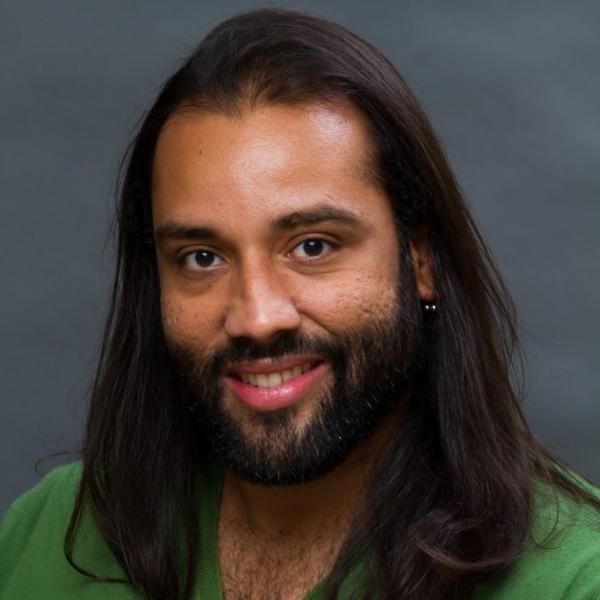 Man with long, dark hair and a green sweater