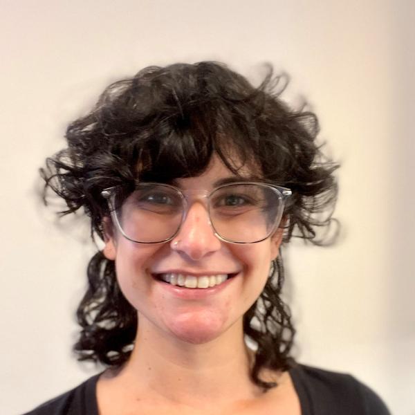 Woman with short, curly black hair and black shirt